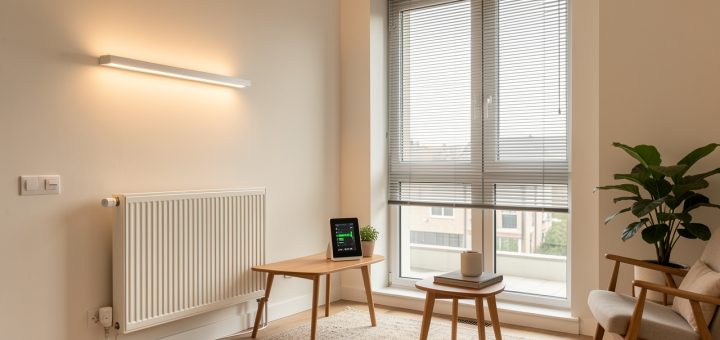 Intérieur moderne d’un appartement équipé de thermostats connectés, de lampes LED, de stores automatisés et d’un système de suivi de la consommation énergétique.